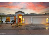 Charming home featuring a three-car garage, desert landscaping, and stunning sunset views at 22222 N 54Th Way, Phoenix, AZ 85054