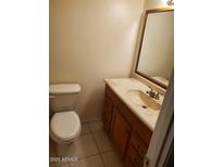 A quaint bathroom with a single sink, wood vanity, and tiled flooring at 2549 W Rose Ln # A223, Phoenix, AZ 85017