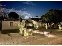 Charming home featuring manicured landscaping and an inviting walkway with accent lighting at nighttime at 2719 N Greenfield Rd, Phoenix, AZ 85006