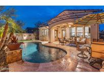 Beautiful backyard featuring a shimmering pool, covered patio, and outdoor seating area perfect for entertaining at 31061 N 136Th Ln, Peoria, AZ 85383