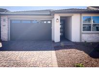 Charming single-story home featuring a gray garage door, and a brick driveway at 5407 W Las Palmaritas Dr, Glendale, AZ 85302