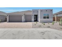 Beautiful single-story home featuring a well manicured gravel yard and a brick driveway leading to a two car garage at 18447 W Mohave St, Goodyear, AZ 85338