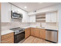 Modern kitchen with stainless steel appliances, white cabinets, and quartz countertops at 4201 E Camelback Rd # 28, Phoenix, AZ 85018