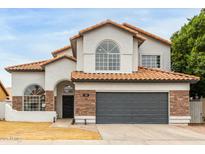 Charming two-story home with a two car garage, clay tile roof, and brick and stucco exterior at 725 W Palo Verde St, Gilbert, AZ 85233