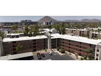 Scenic aerial view of a residential community surrounded by lush landscaping with a mountain in the background at 7625 E Camelback Rd # A110, Scottsdale, AZ 85251