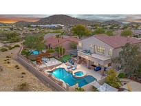 Expansive backyard with a stunning pool, spa, outdoor kitchen, play area and mountain views at 9867 S 182Nd Dr, Goodyear, AZ 85338