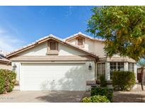 Charming home featuring a two-car garage, tile roof, and manicured landscaping at 20615 N 105Th Ave, Peoria, AZ 85382