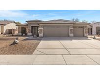 Charming single-story home featuring a three-car garage and desert-style landscaping at 2561 E Toledo Ct, Gilbert, AZ 85295