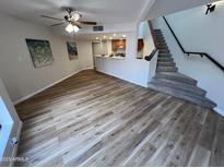 Inviting living room featuring hardwood floors, a ceiling fan, and stairs leading to the next level at 3228 W Glendale Ave # 103, Phoenix, AZ 85051
