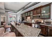 Spacious kitchen featuring granite countertops, stainless steel appliances, and dark wood cabinets at 541 E Ames Pl, Phoenix, AZ 85004