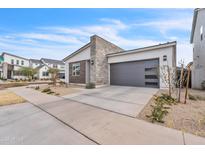 Attractive home featuring a modern design, stone accents, and a well-kept front yard at 5611 S Feliz --, Mesa, AZ 85212