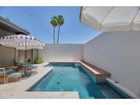 Private pool area with stylish tile, sun umbrellas, lounge seating, and sunny views at 6649 N Majorca E Ln, Phoenix, AZ 85016