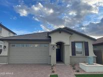 Charming single-story home with a brick walkway and an attached two-car garage at 9965 W Flower St, Avondale, AZ 85392