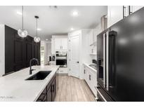 This kitchen offers white cabinets, a quartz countertop, and a stainless steel range hood at 13342 W Lariat Ln, Peoria, AZ 85383