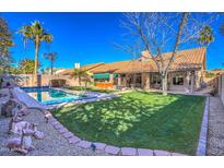 Expansive backyard boasts a sparkling pool, verdant lawn, mature trees, and ample space for recreation and relaxation at 16402 N 48Th Way, Scottsdale, AZ 85254