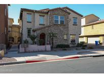 Charming two-story home with a stone facade, front patio and manicured landscaping at 1722 N 77Th Gln, Phoenix, AZ 85035