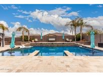 Inviting backyard pool with a luxurious stone waterfall feature and resort-style lounging at 19349 W Oregon Ave, Litchfield Park, AZ 85340