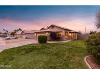 Charming single-story home featuring a lush green lawn, desert landscaping, and a welcoming facade at 1993 S Spartan St, Gilbert, AZ 85233