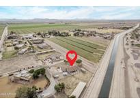 Stunning aerial view of a charming rural community surrounded by lush green fields and mountains at 21520 W Watkins St, Buckeye, AZ 85326