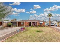 Charming brick home with a well-manicured lawn, mature palm tree, and a welcoming front porch at 2230 N 14Th Pl, Phoenix, AZ 85006