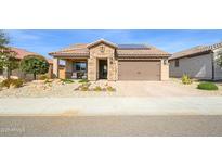 Charming single-story home featuring a two car garage, beautiful desert landscaping, and a stone facade at 26578 W Piute Ave, Buckeye, AZ 85396