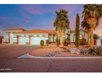 Stunning desert home featuring lush landscaping, a red tiled roof, and an attached three-car garage at 2903 S 271St Ln, Buckeye, AZ 85326