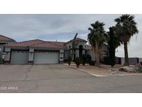 Charming single-story home boasts desert landscaping, mature palm trees, and a spacious three-car garage at 2903 S 271St Ln, Buckeye, AZ 85326