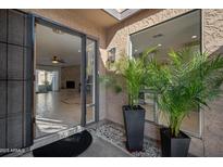 Inviting entryway with desert landscaping, and a glimpse into the open-concept living area with fireplace at 3033 N 37Th St # 14, Phoenix, AZ 85018