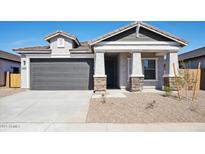 Charming single-story home featuring a two-car garage, neutral stucco, and stone-accented pillars at 42490 W Vincent Dr, Maricopa, AZ 85138