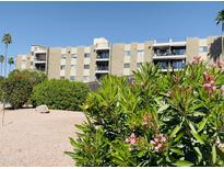 Inviting condo building featuring balconies and lush landscaping with flowering bushes in a well-maintained community at 425 S Parkcrest -- # 323, Mesa, AZ 85206