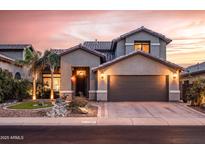 Charming two-story home with desert landscaping, a two car garage, and warm exterior lighting at 4365 E Anderson Dr, Phoenix, AZ 85032