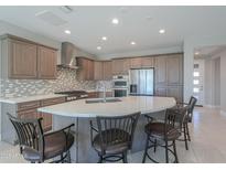 Beautiful kitchen features stainless steel appliances, a large island with seating, and plenty of cabinet space at 5091 N Bryce Canyon Dr, Eloy, AZ 85131