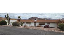 Charming exterior of a single story home with desert landscaping, mountain views and a red tile roof at 981 N Sherwood Way, Queen Valley, AZ 85118