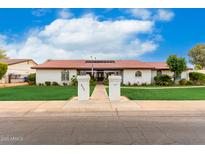 Charming single-story home with a red tile roof, green lawn, mature trees, and inviting walkway at 109 W Kathleen Rd, Phoenix, AZ 85023