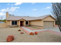 Charming single-story home with a desert landscape, tile roof, and inviting red front door at 14005 N 19Th Way, Phoenix, AZ 85022