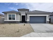 Charming single-story home featuring stone accents, a gray exterior, and a low-maintenance gravel yard at 1503 S 239Th Dr, Buckeye, AZ 85326