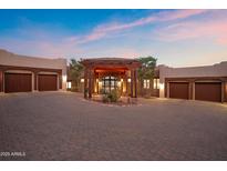 Stunning home exterior with a paver driveway, porte cochere, and lush landscaping, perfect for luxurious living at 15504 E Firerock Country Club Dr, Fountain Hills, AZ 85268