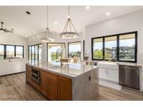 Bright kitchen featuring a large island with granite countertop, modern lighting, and stainless steel appliances at 15747 E Greystone Dr, Fountain Hills, AZ 85268