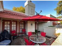 Outdoor patio with a red umbrella, dining table, and red chairs, perfect for relaxing or entertaining at 3535 W Monte Cristo Ave # 129, Phoenix, AZ 85053