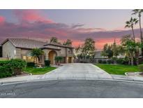 Stunning two-story home with an attached garage, well-manicured lawn, mature trees and a beautiful sunrise at 3603 E Indigo Bay Ct, Gilbert, AZ 85234