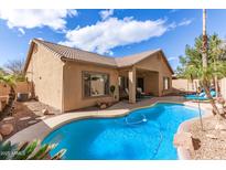 Inviting backyard pool with lush tropical landscaping and covered patio, ideal for relaxation at 545 N Bluejay Dr, Gilbert, AZ 85234