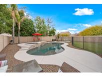 Sparkling backyard pool with spa, lounge chairs, and a well-maintained privacy fence at 17771 W Caribbean Ln, Surprise, AZ 85388