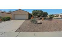 Charming single-story home with desert landscaping, two-car garage, and extended driveway at 18670 N Rincon Ct, Surprise, AZ 85387