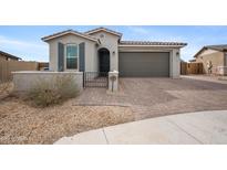 Charming single-story home with desert landscaping, brick driveway, and an attached two-car garage at 24267 W Gibson Ln, Buckeye, AZ 85326