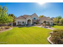 Charming single-story home featuring a well-manicured lawn, lush landscaping, and a welcoming entryway at 2467 E Page Ave, Gilbert, AZ 85234