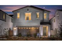 Two-story home showcasing a front-entry two-car garage and decorative brickwork at 2468 W Rowel Rd, Phoenix, AZ 85085