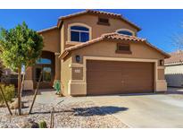 Two-story home with a desert landscape, two car garage, and a charming arched entry at 35030 N Barzona Trl, San Tan Valley, AZ 85143