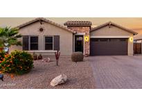 Charming home exterior with stone accents, desert landscaping, and a two-car garage at 902 W Desert Valley Dr, San Tan Valley, AZ 85143