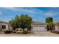 Cozy home featuring manicured landscaping, mature trees, and a classic two-car garage at 9213 W Clara Ln, Peoria, AZ 85382