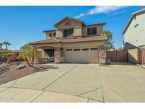 Two-story tan home featuring a two car garage, desert landscaping, and stone accents at 14104 N 146Th Ln, Surprise, AZ 85379